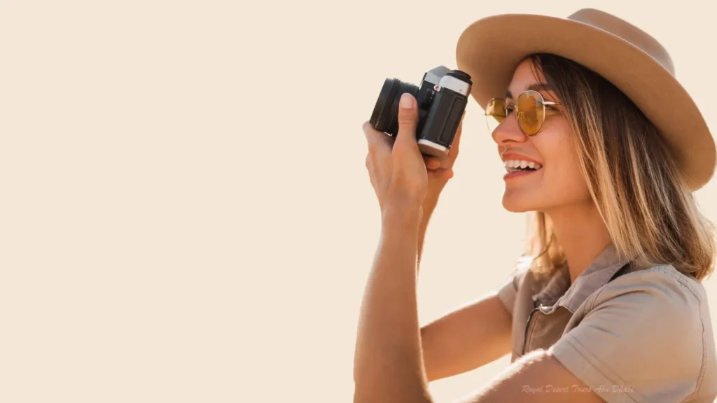 Tourist capturing the golden sunrise during a morning desert safari in Abu Dhabi.